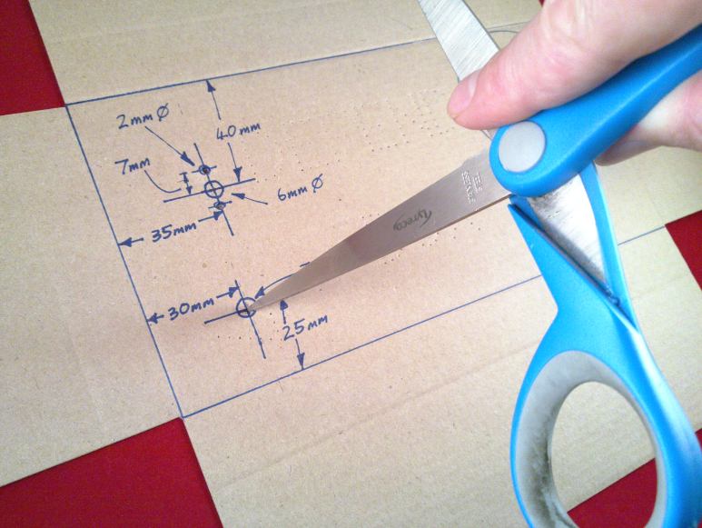 Making the larger hole by spinning round the scissors